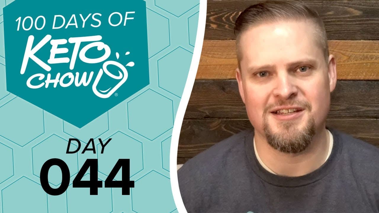 Graphic overlay with 100 DAYS OF KETO CHOW logo featuring a stylized cup with a splash, on a teal hexagonal pattern background. Black text below reads DAY 044.