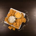Top view - Chicken Crackers on a white plate with two small bowls of dip.