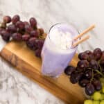Side view - Purple Cow Float in tall glass with grapes on the side.