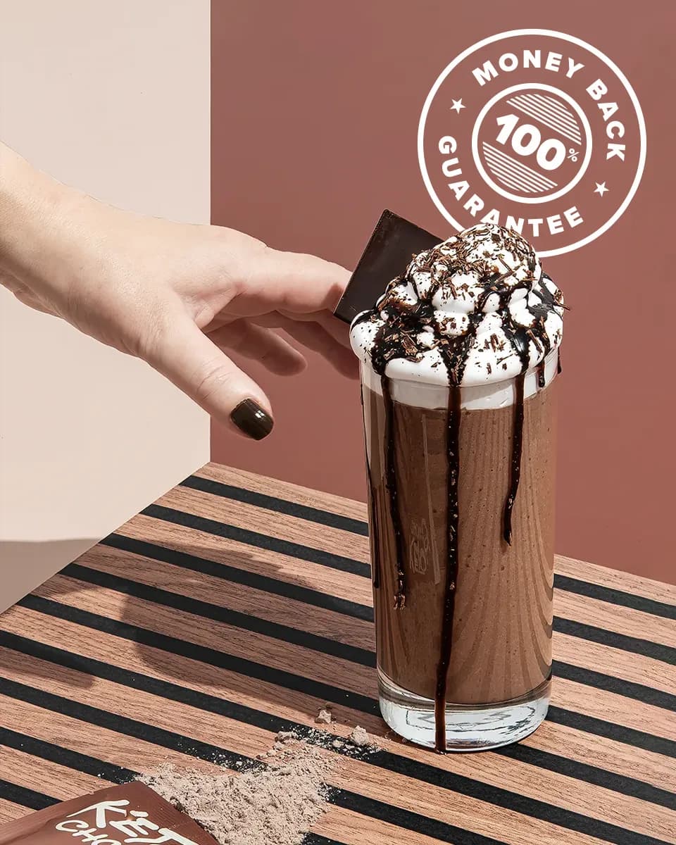 A hand reaching for a Chocolate Keto Chow shake