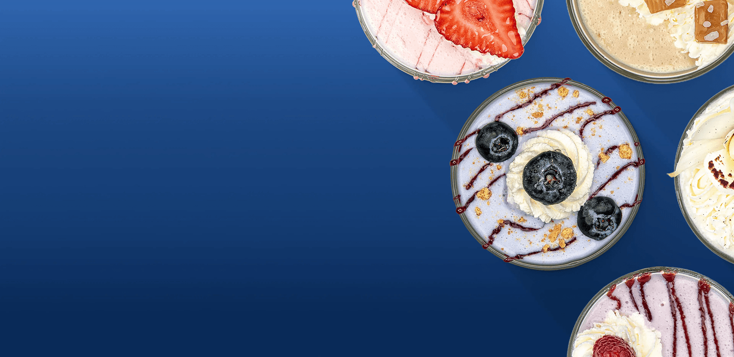 Five circular dessert bowls with various toppings are on a solid blue background.