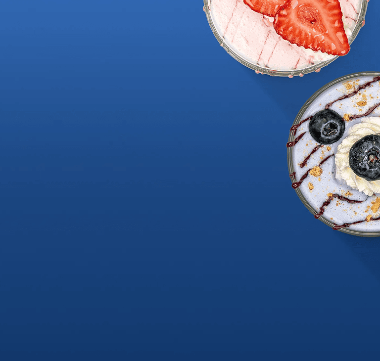 Two circular dessert bowls are on a solid blue background.