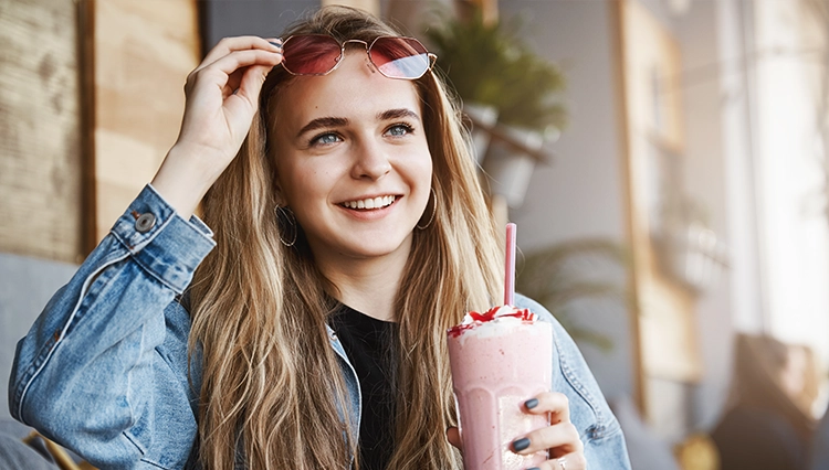 a woman holding a pink Keto Chow shake