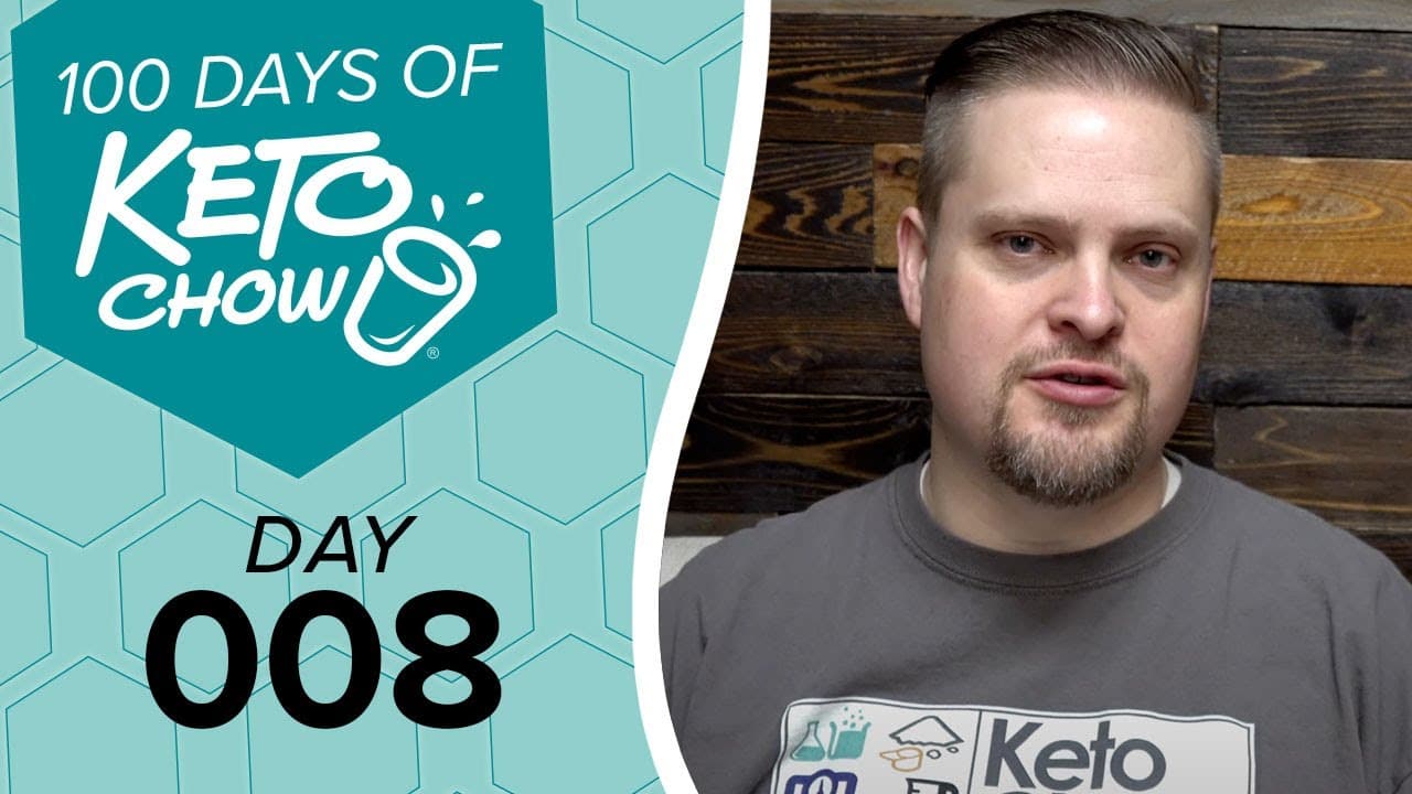Keto Chow graphic with 100 DAYS OF KETO CHOW DAY 008, white shaker logo, teal hexagonal background. Man in grey Keto Chow shirt.