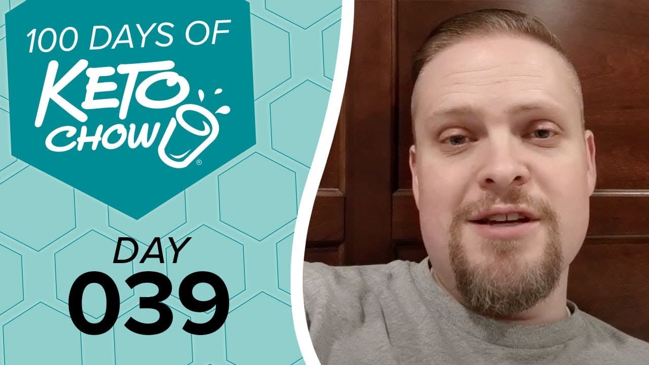 Graphic with 100 DAYS OF KETO CHOW and DAY 039 text on a teal and light blue hexagonal background, beside a man in a grey shirt.