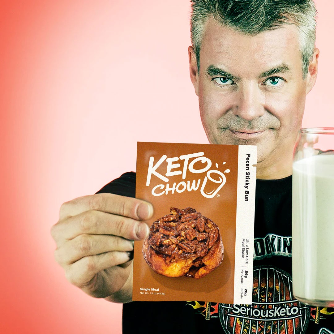 Steve from Serious Keto holding a pecan sticky bun keto chow single meal packet in one hand and a cup of pecan sticky bun keto chow in the other hand